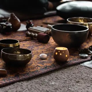 Cuencos tibetanos y una vela preparados para un viaje sonoro