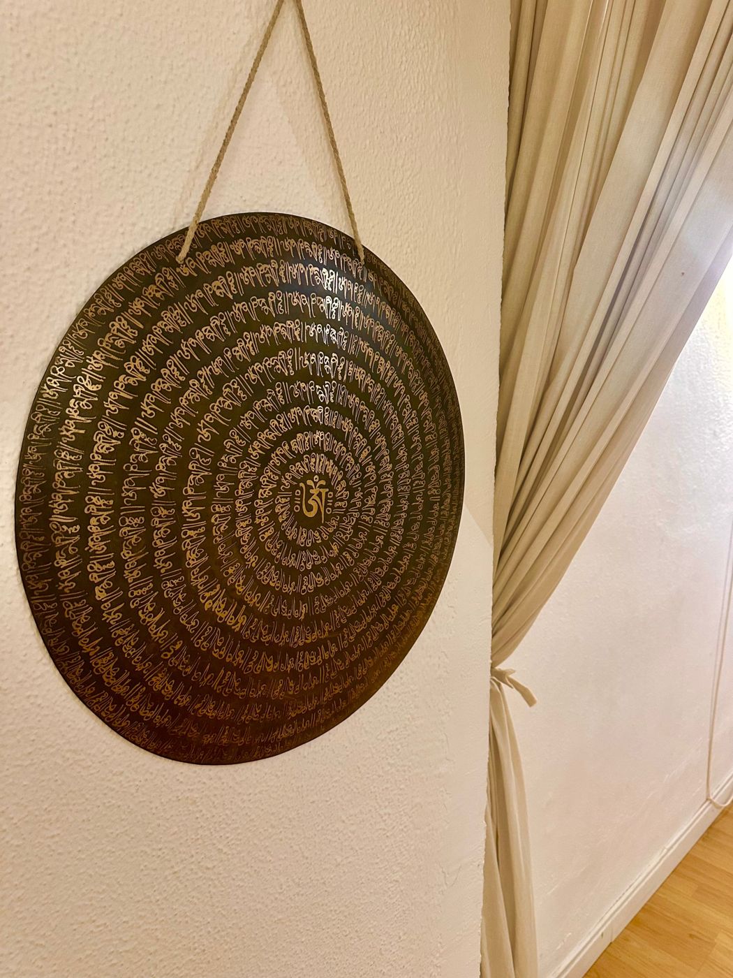 Gong grabado con mantras colgado en la pared del estudio